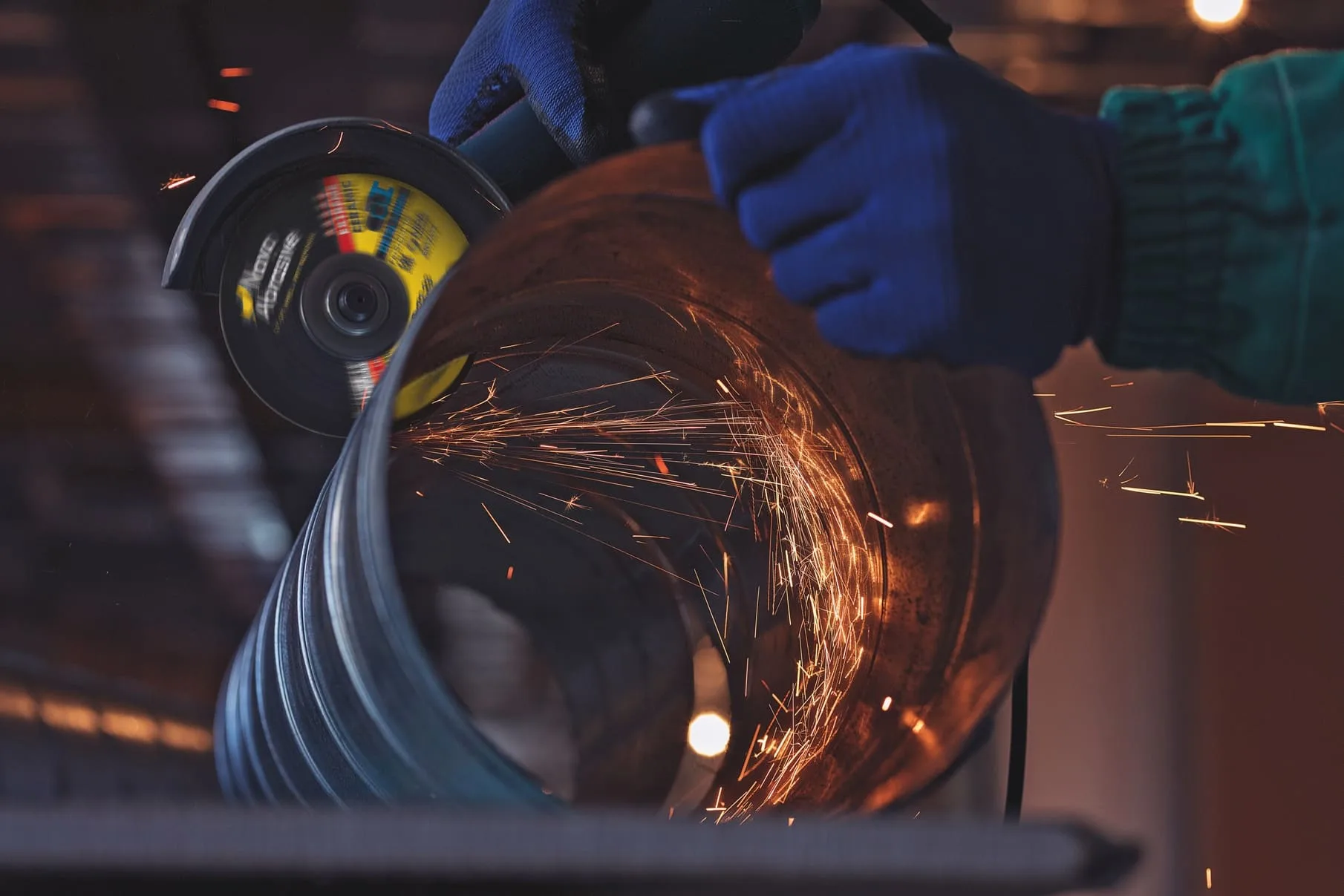 Працівник у повному комплекті ЗІЗ безпечно працює з болгаркою