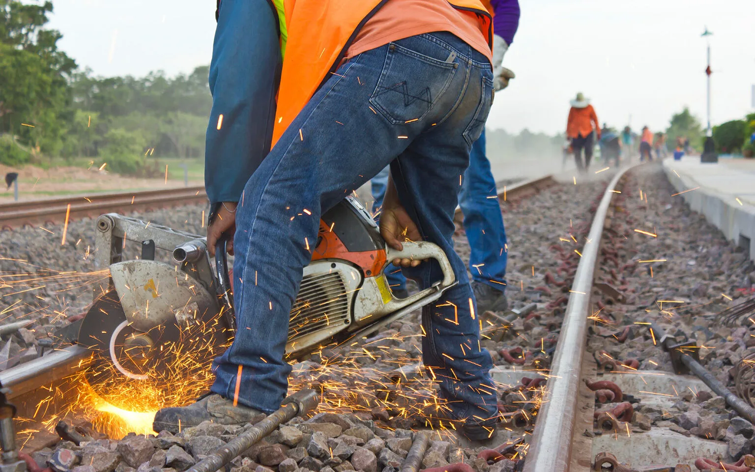 A worker in full PPE safely works with a grinder